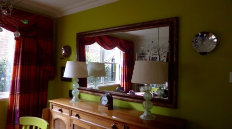 Large mirror on plasterboard wall with candle sconces